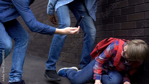Cruel teenagers mocking boy and making video on smartphone, cyberbullying