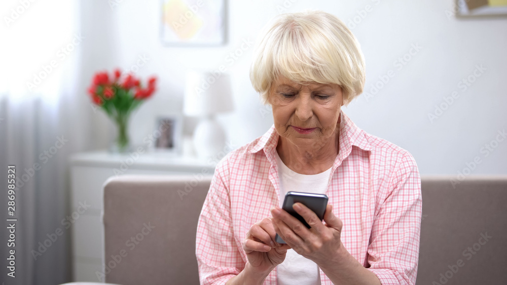 Serious elderly woman learning using new smartphone, technology for old people Serious elderly woman learning using new smartphone, technology for old people