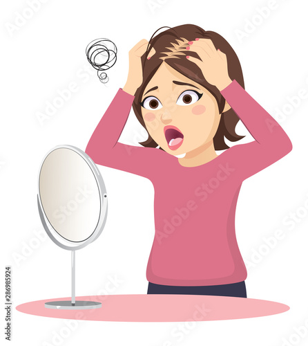 Young woman losing hair in front of mirror