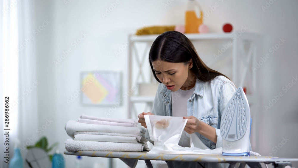 Upset female makes burn stain on shirt during ironing, housekeeping problem Upset female makes burn stain on shirt during ironing, housekeeping problem