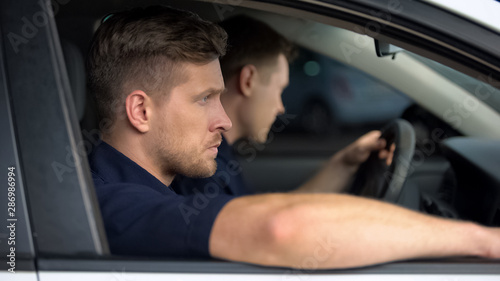 Fotografie Male security guards sitting in car, monitoring safety, private investigators