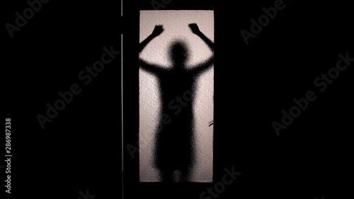 Leinwand Poster Hopeless woman knocking with fists at closed door, running from murderer, fear
