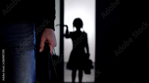 Canvastavla Silhouette of little girl entering room, violent father with belt on foreground