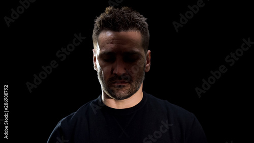 Man closed eyes in shadow black background, mental disorder, crisis depression