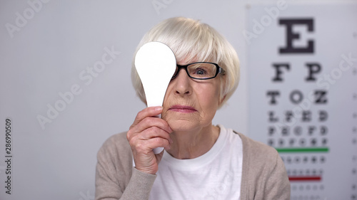 Εκτύπωση καμβά Female retiree in glasses closing eye and shaking head, age related diseases