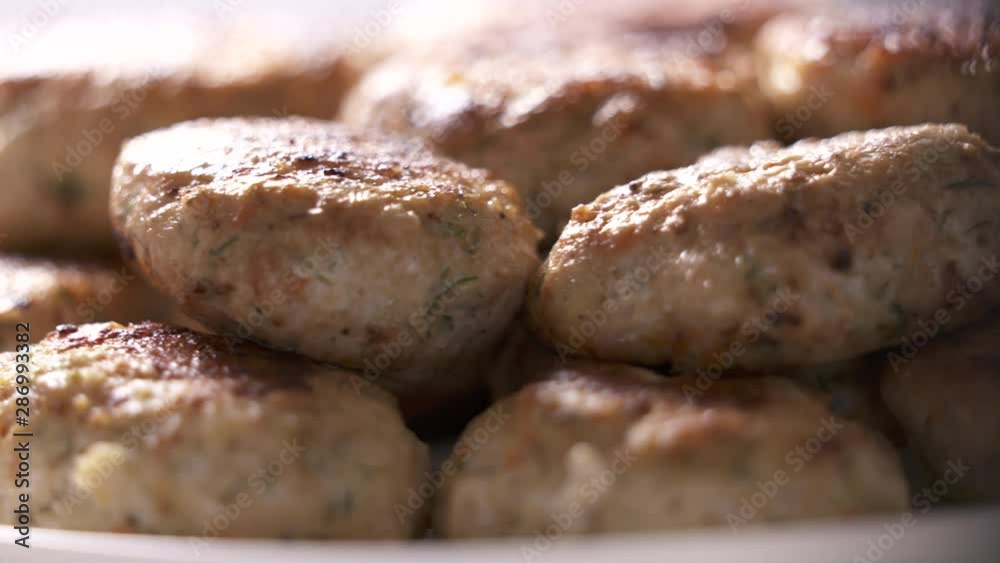 Pile of fried chicken cutlets on plate rotating