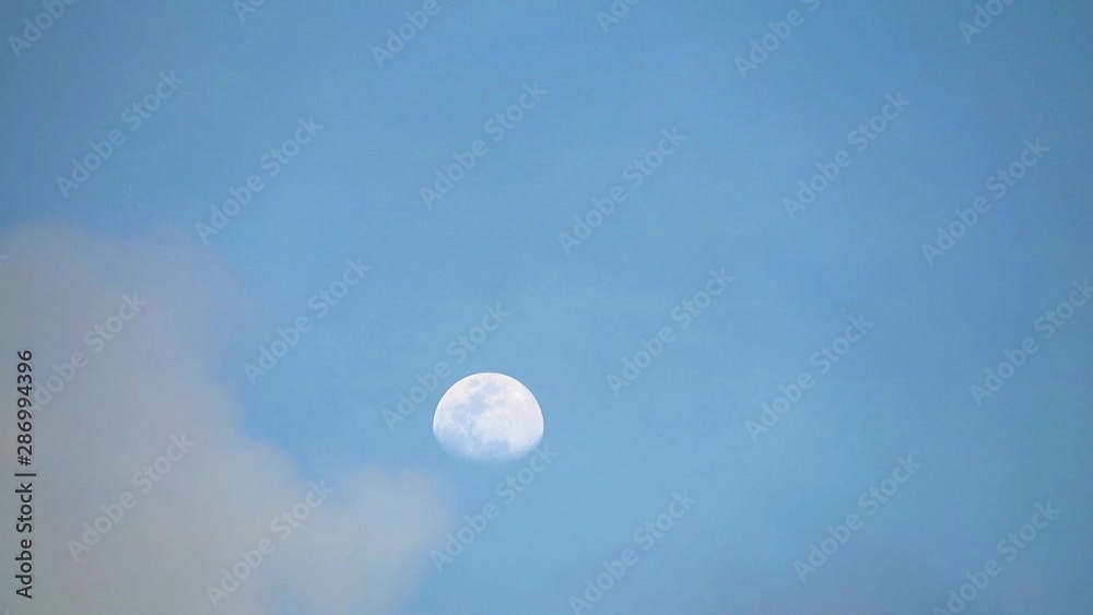 half moon on blue sky and dark cloud moving pass half moon on blue sky and dark cloud moving pass