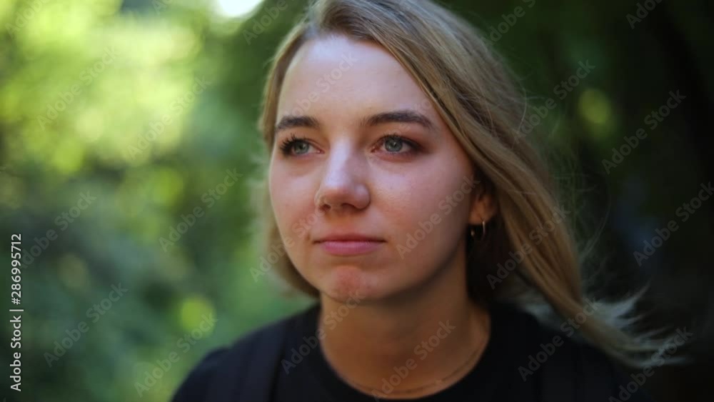 Slow Motion Shot of a beautiful blonde female sitting in the mountains and she is staring off in the distance. Slow Motion Shot of a beautiful blonde female sitting in the mountains and she is staring off in the distance.