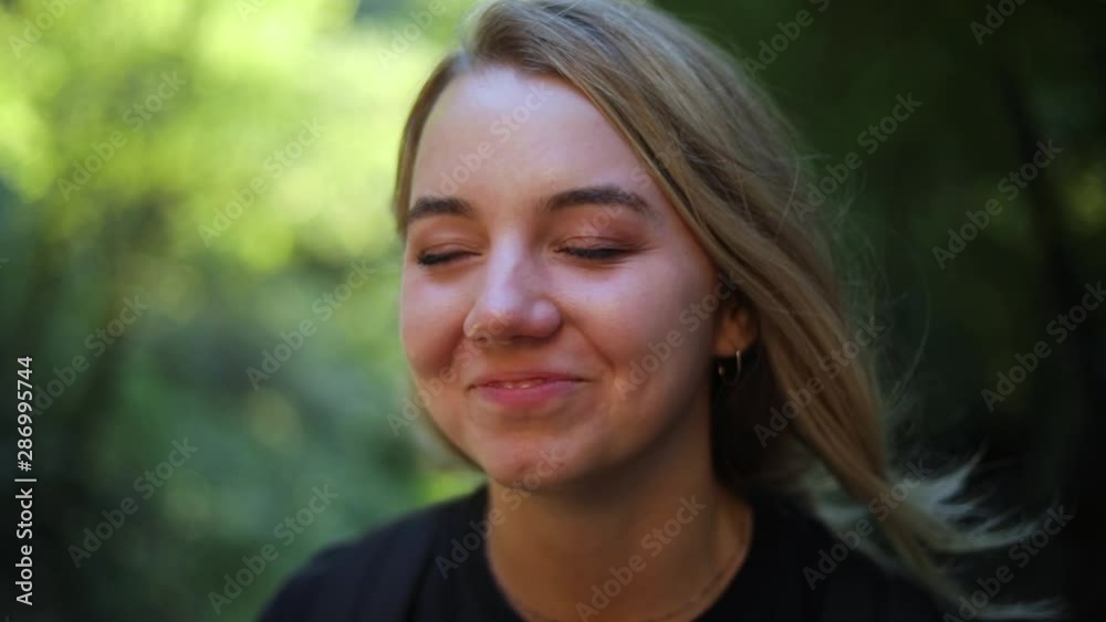 Slow Motion Shot of a beautiful blonde female sitting in the mountains. She is staring off in the distance and then she busts up laughing. Slow Motion Shot of a beautiful blonde female sitting in the mountains. She is staring off in the distance and then she busts up laughing.