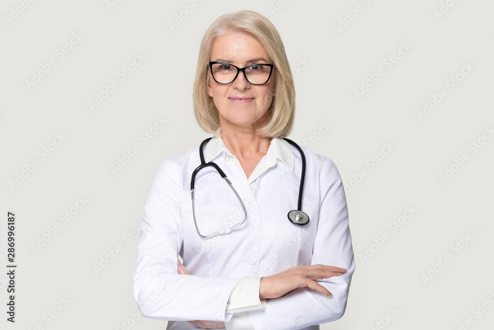 Portrait of mature female doctor isolated on grey background Portrait of mature female doctor isolated on grey background