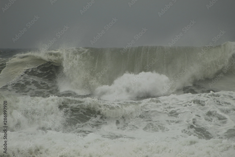 Fototapeta premium Surfing the waves on the beach of Matosinhos in Porto, Portugal. August 2019