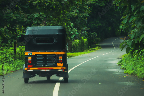 A three wheeler vehicle in the road