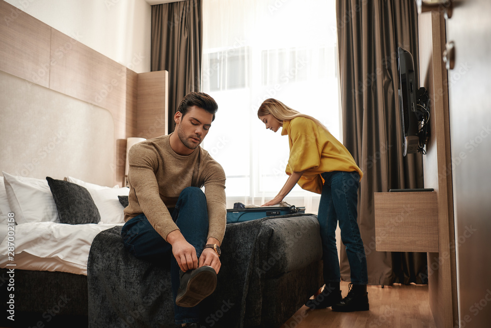 Unpacking. Couple enjoys staying together in a hotel Unpacking. Couple enjoys staying together in a hotel