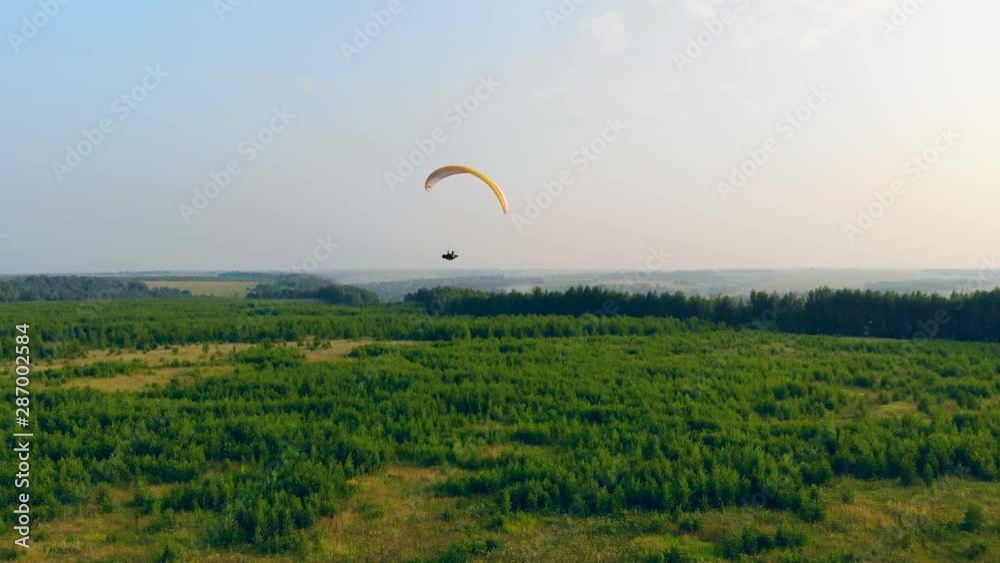 Paraplane is flying over the green plains Paraplane is flying over the green plains
