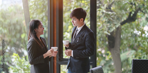 Photos Young professional asian business partner having coffee break and chatting