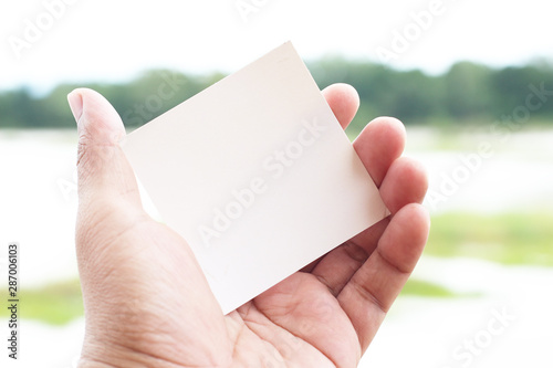 Hand hold white blank business card paper at outdoor