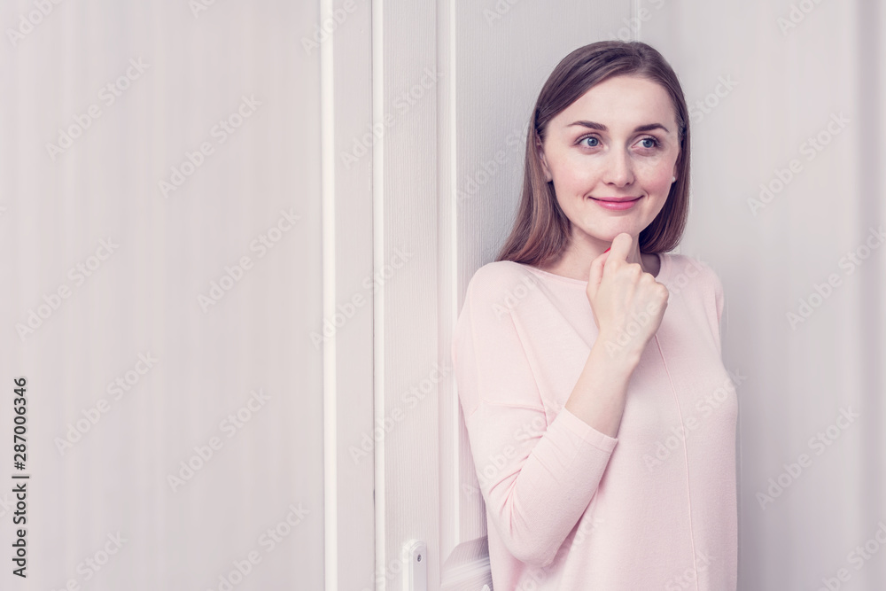Sly girl hiding, standing behind white door, toned, copy space Sly girl hiding, standing behind white door, toned, copy space