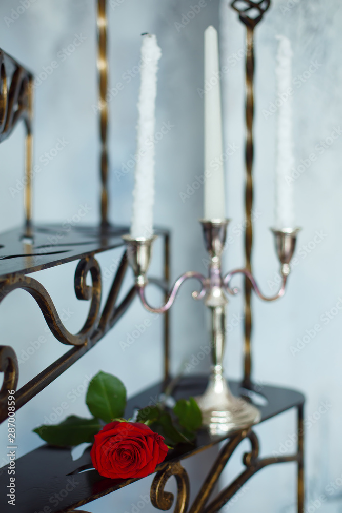 red rose flower and candles on a metal staircase red rose flower and candles on a metal staircase