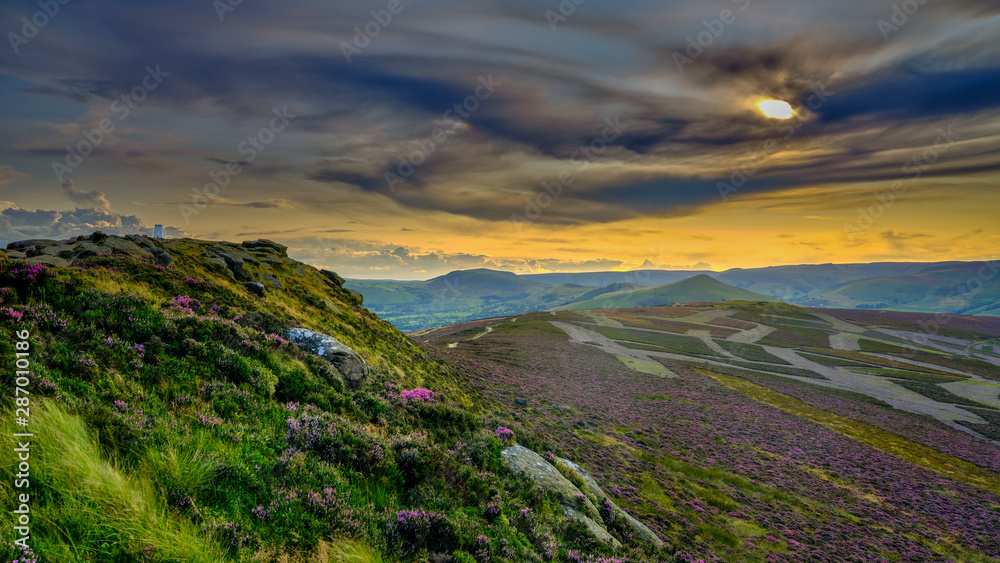 Fototapeta premium Heather and sunset over the Hope Valley from Win Hill in the Peak District National Park