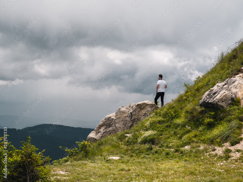 Man admiring the landscape of the Carpathian Mountains, in Transylvania (Romania)