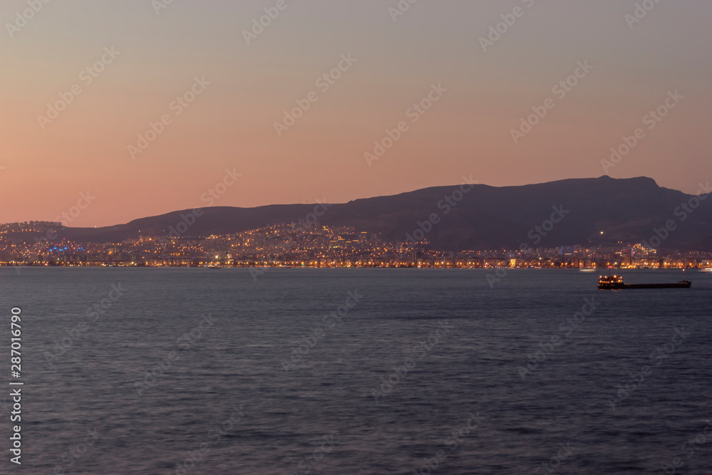 Sunset view over the bay in Izmir,ship and mountains