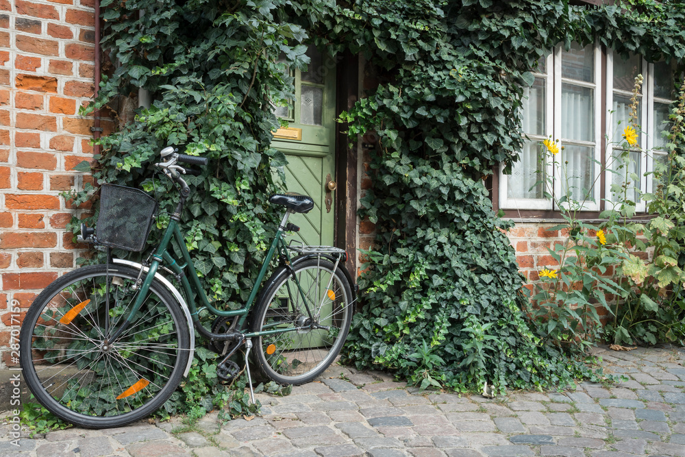 Old bike in front of a historic house. Old bike in front of a historic house.