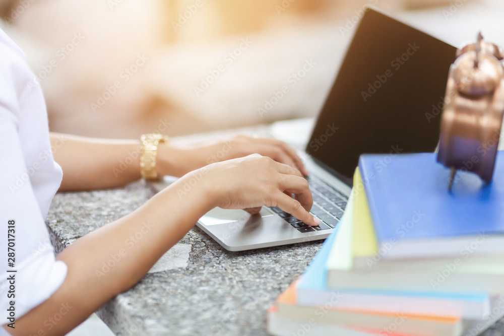 Fototapeta premium The working student is using the computer to print his work with intent, education and school concept.