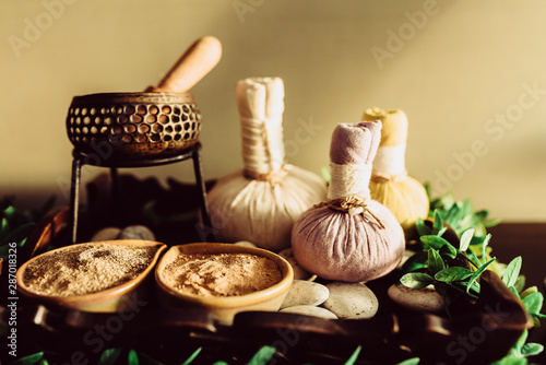 Herbs powder for traditional spa on wooden background photo