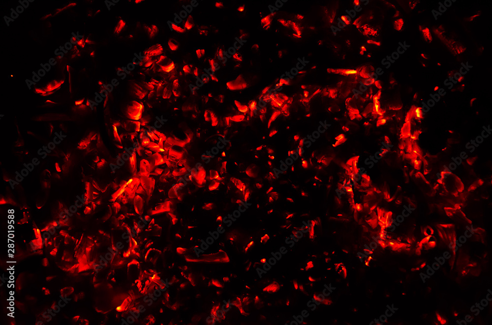 Actively smoldering embers of fire. Background of burning hot coals. Flicker of burning coals at night Actively smoldering embers of fire. Background of burning hot coals. Flicker of burning coals at night