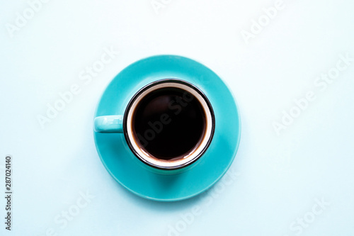 blue instant coffee Cup on saucer on blue background close-up, copy space top view flat lay