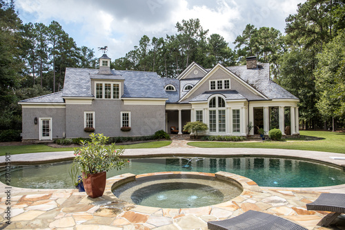 Rear exterior view of large custom built new home with swimming pool on a large secluded lot 