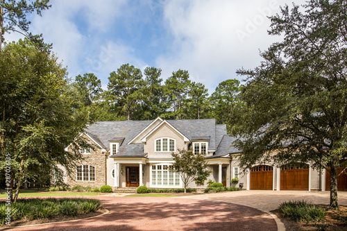 Foto Front view of large estate home in the south with a gravel driveway and lots of windows