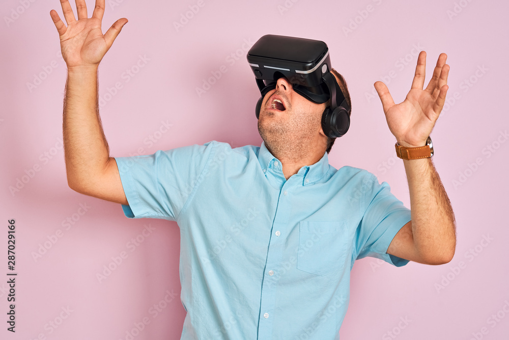 Naklejka premium Young plus size man playing virtual reality game using goggles