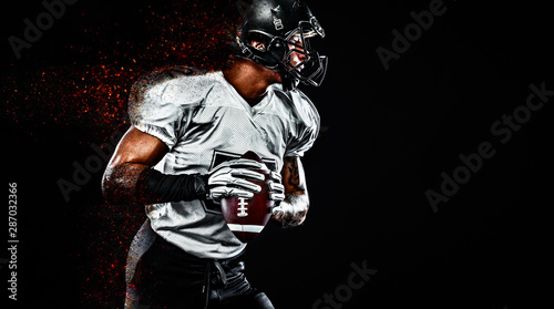 American football player. Sportsman with ball in helmet on stadium in action. Sport wallpaper. Team sports.