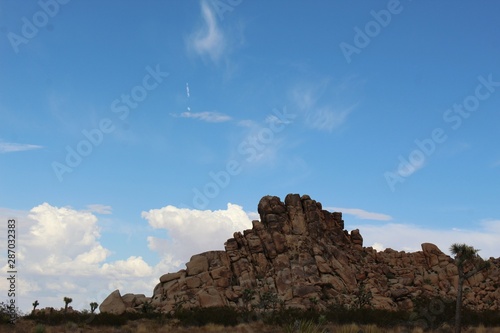 Clouds coalesce over the Southern Mojave Desert, accenting rock formations and native plants of the Little San Bernardino Mountains in Joshua Tree National Park.