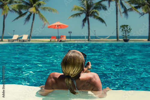 Beautiful woman relaxing in a pool at summer