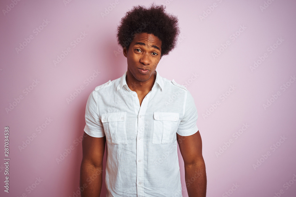 Young american man with afro hair wearing white shirt standing over isolated pink background depressed and worry for distress, crying angry and afraid. Sad expression. Young american man with afro hair wearing white shirt standing over isolated pink background depressed and worry for distress, crying angry and afraid. Sad expression.