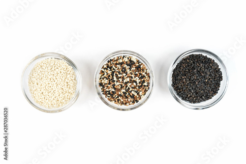Sesame seeds in glass containers on a white background.
