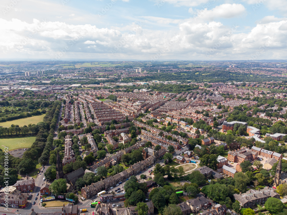 Aerial photo over looking the area of Leeds known as Headingley in West Yorkshire UK, showing a typical British hosing estate with fields and roads taken with a drone on a sunny day