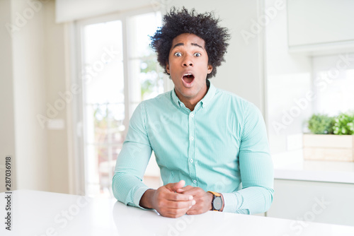 African American business man wearing elegant shirt afraid and shocked with surprise expression, fear and excited face.