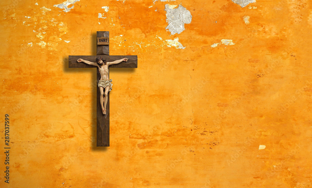 Catholic, christian cross on a shabby wall.