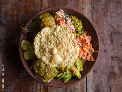 Bowl of variety of traditional vegan Sri Lankan food with different curries, papadum, rice, sambol, dal and vegetables, Ella, Sri Lanka.