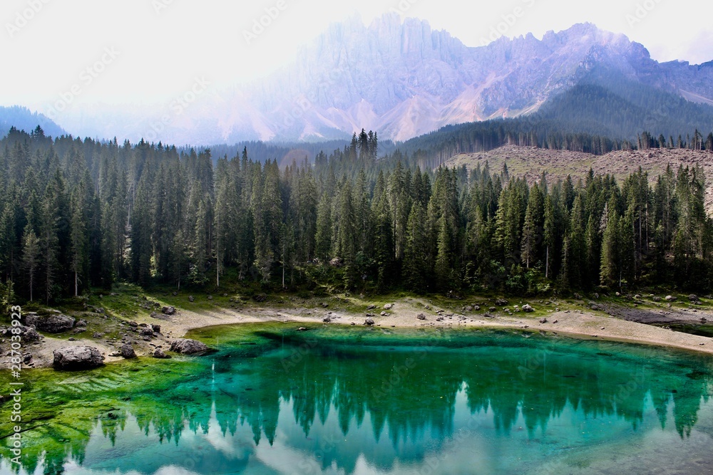 Lake Carezza, the small mountain lake is famous for the dark green color, and the beautiful panorama of mountains in the background. Legend of King Laurin and his Rosegarden. South Tyrol, Italy. I