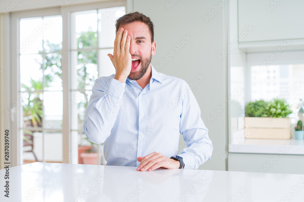 Handsome business man covering one eye with hand with confident smile on face and surprise emotion. Handsome business man covering one eye with hand with confident smile on face and surprise emotion.