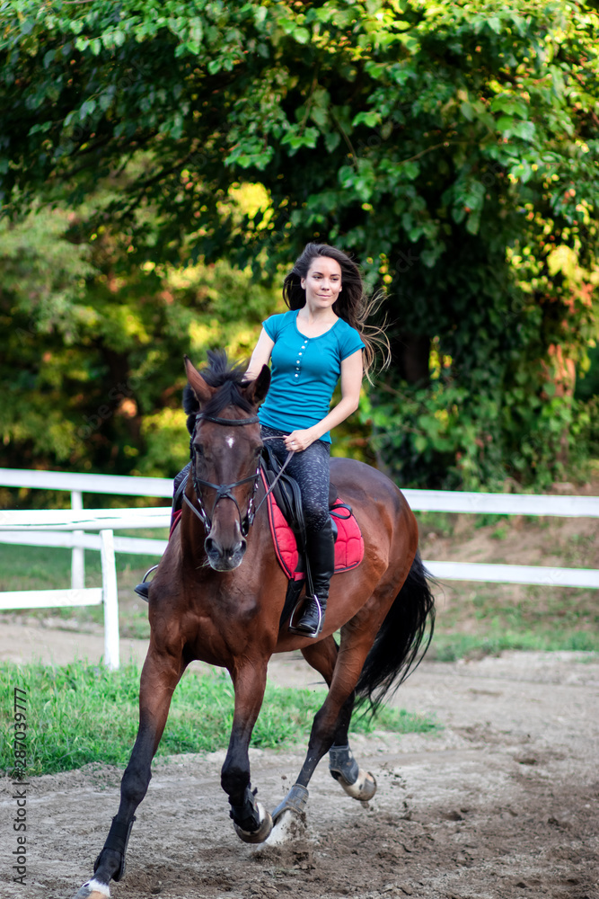 Young beautiful brunette girl riding on a horse. Young beautiful brunette girl riding on a horse.