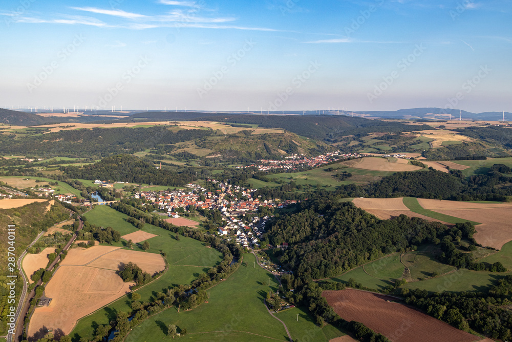 Aerial view at a landscape in Germany, Rhineland Palatinate near Bad Sobernheim with the river Nahe, the village Staudernheim, meadow, farmland, forest, hills, mountains