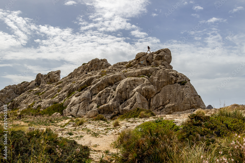 Landscape with rock formation  at Punto de la Salada on balearic island Mallorca, Spain on a sunny day with blue sky and white clouds