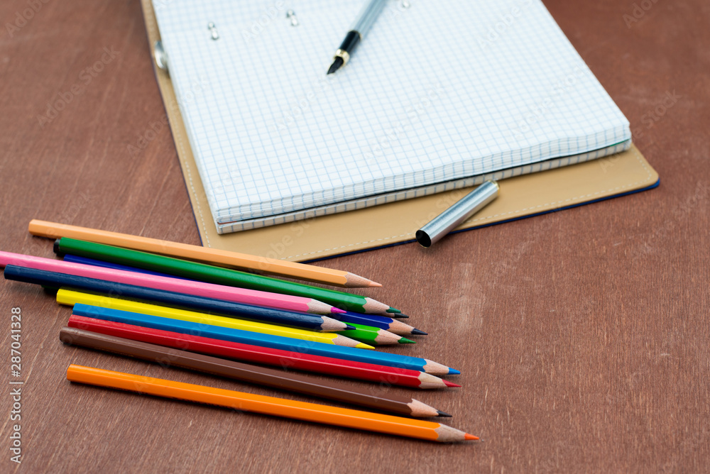 Blank paper and colorful pencils on old wooden table. Flat lay, top view.