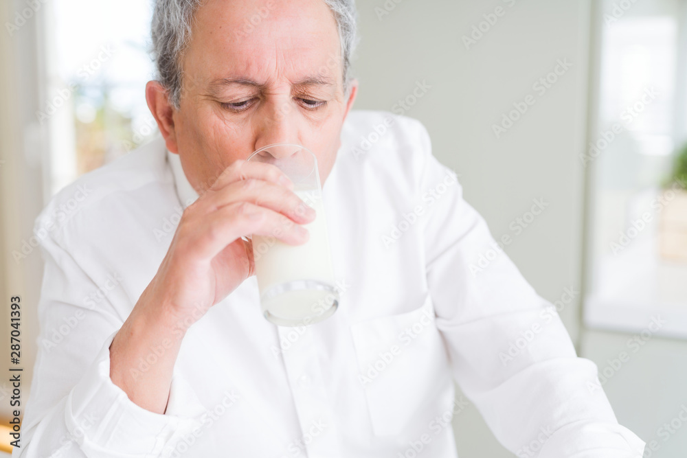 Handsome senior man drinking a glass of fresh milk in the morning Handsome senior man drinking a glass of fresh milk in the morning