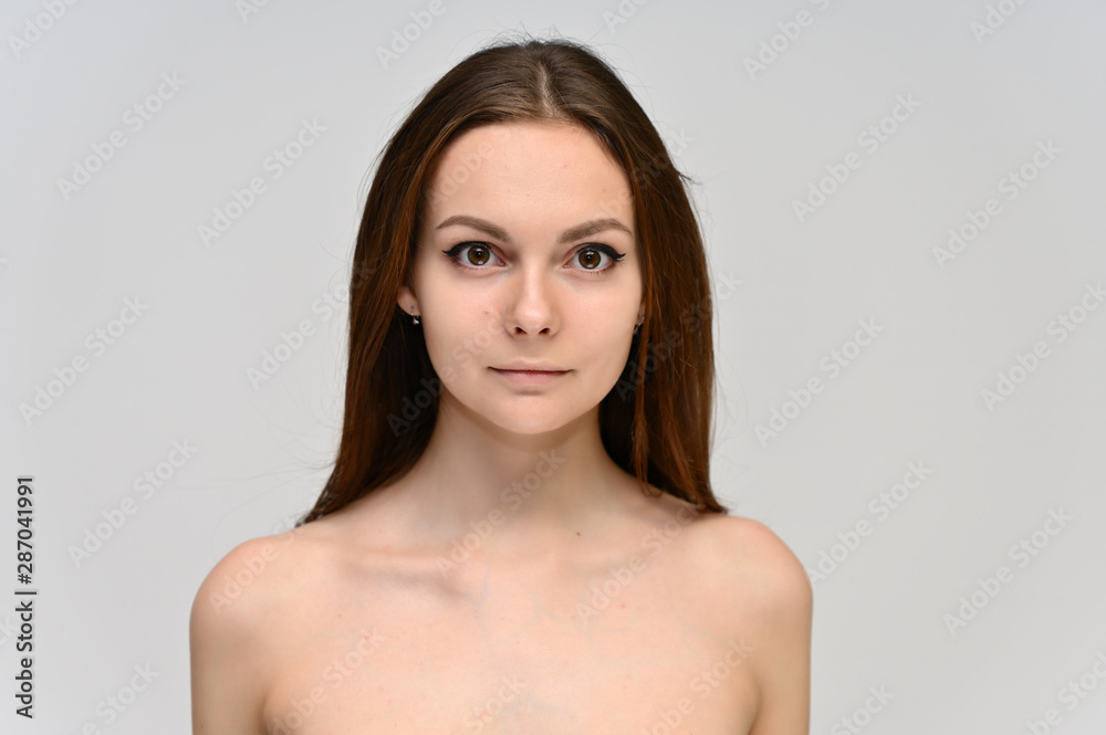 Obraz premium Close-up Portrait of a cute brunette girl, a young woman with beautiful curly hair and beautiful face skin. Beauty, brightness, smile, health.